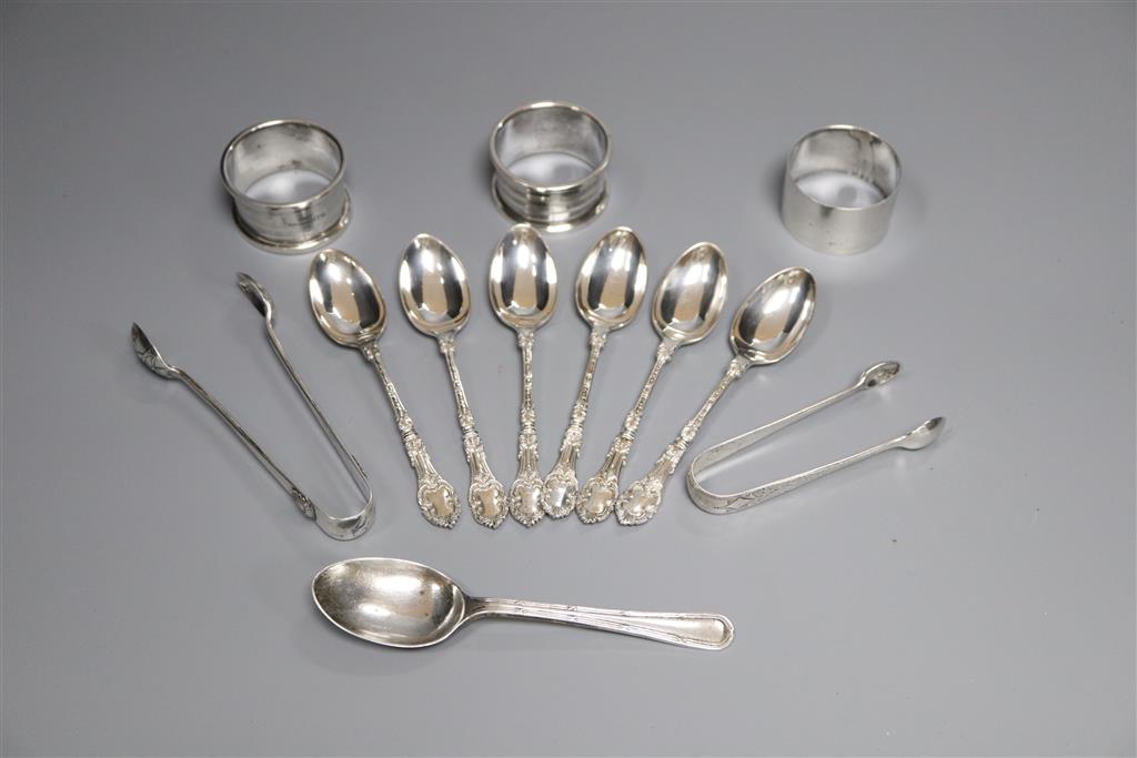 Three silver napkin rings, a set of six silver teaspoons, one other spoon and two pairs of silver sugar tongs,